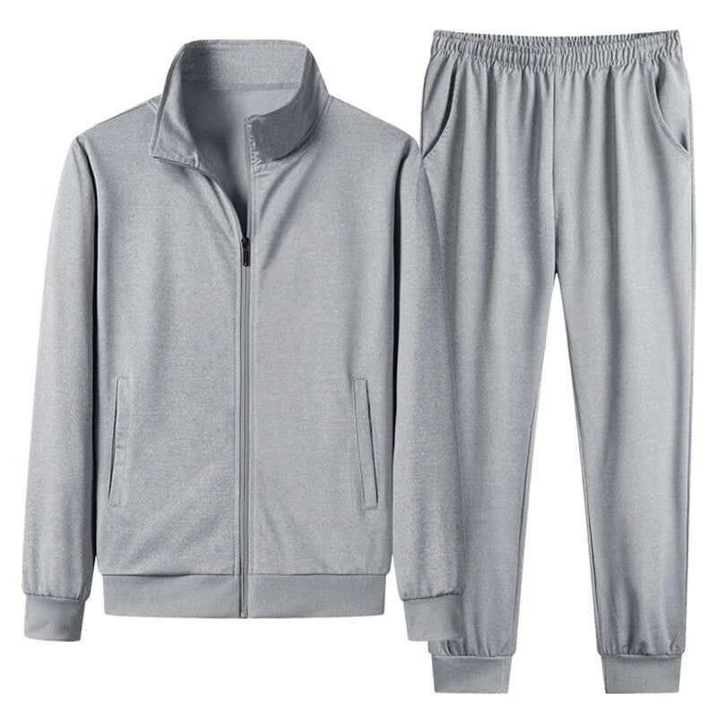 Grauer Trainingsanzug für Herren, bestehend aus Jacke mit Reißverschluss und elastischer Hose. Sportbekleidung, bequem, modern, Freizeitmode.