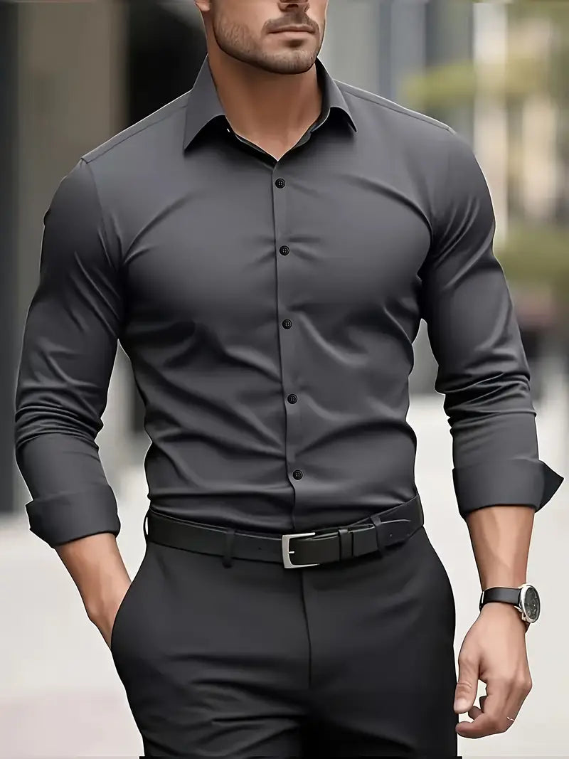 Eleganter Mann in grauem Hemd und schwarzer Hose, trägt eine Uhr und Gürtel. Businessmode, stilvoller Look, urbane Umgebung.