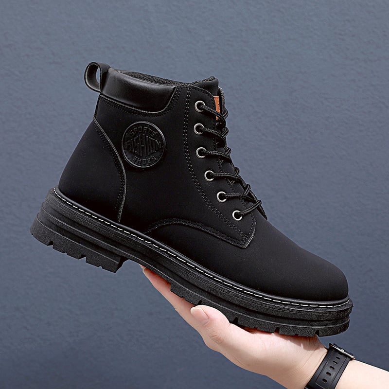 Schwarzer Herrenstiefel mit Schnürung, robustem Profil und Logo-Detail, präsentiert auf einer Hand vor grauem Hintergrund. Ideal für Outdoor-Aktivitäten.