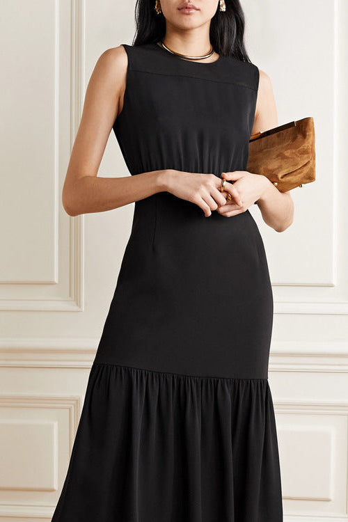 Frau in elegantem schwarzen Abendkleid mit Rüschenrock, hält braune Clutch. Stilvolle Mode, Abendgarderobe, zeitloses Design.