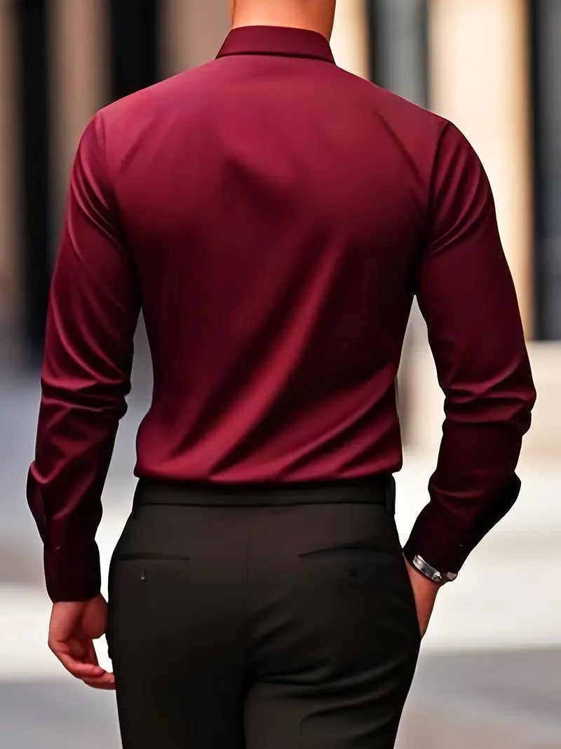 Rückansicht eines Mannes in einem eleganten, weinroten Hemd und schwarzen Hosen, gehend in urbaner Umgebung. Businessmode, Herrenbekleidung, Stil.