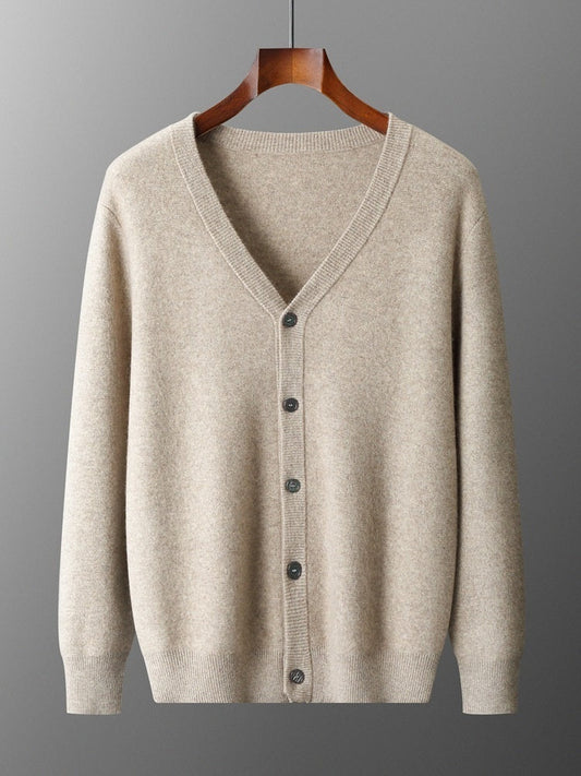 Beige Strickjacke aus Kaschmir, V-Ausschnitt, Knopfleiste, hängend auf Holzkleiderbügel. Elegante, warme Damenmode für Herbst und Winter.