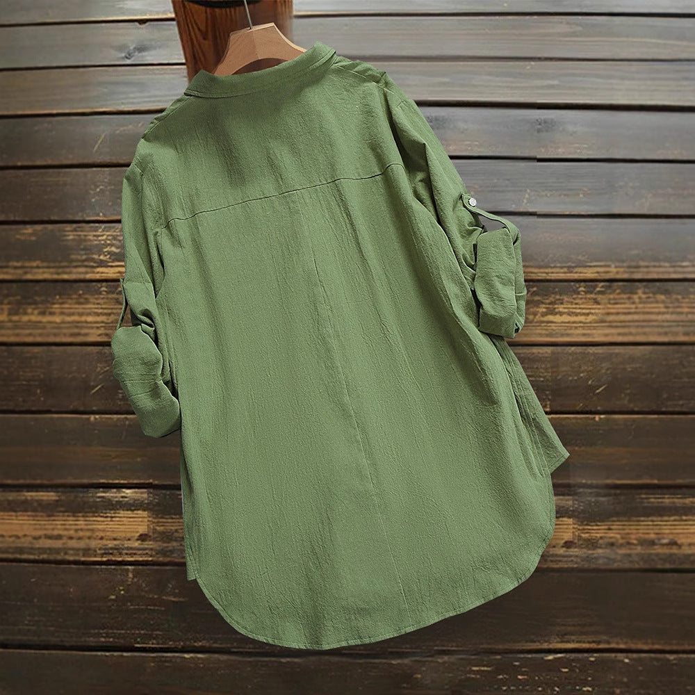 Grünes Damenhemd aus Leinen, lässiger Stil, hängend an Holzwand. Langarm, Knopfleiste, ideal für Freizeitmode und Sommeroutfits.