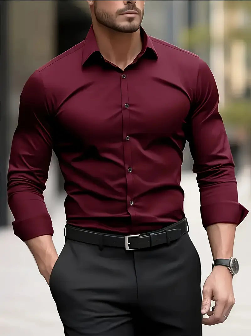 Mann in bordeauxrotem Hemd und schwarzer Hose, stilvoll gekleidet, trägt eine Uhr, geht in urbaner Umgebung. Elegante Herrenmode, Business-Look.
