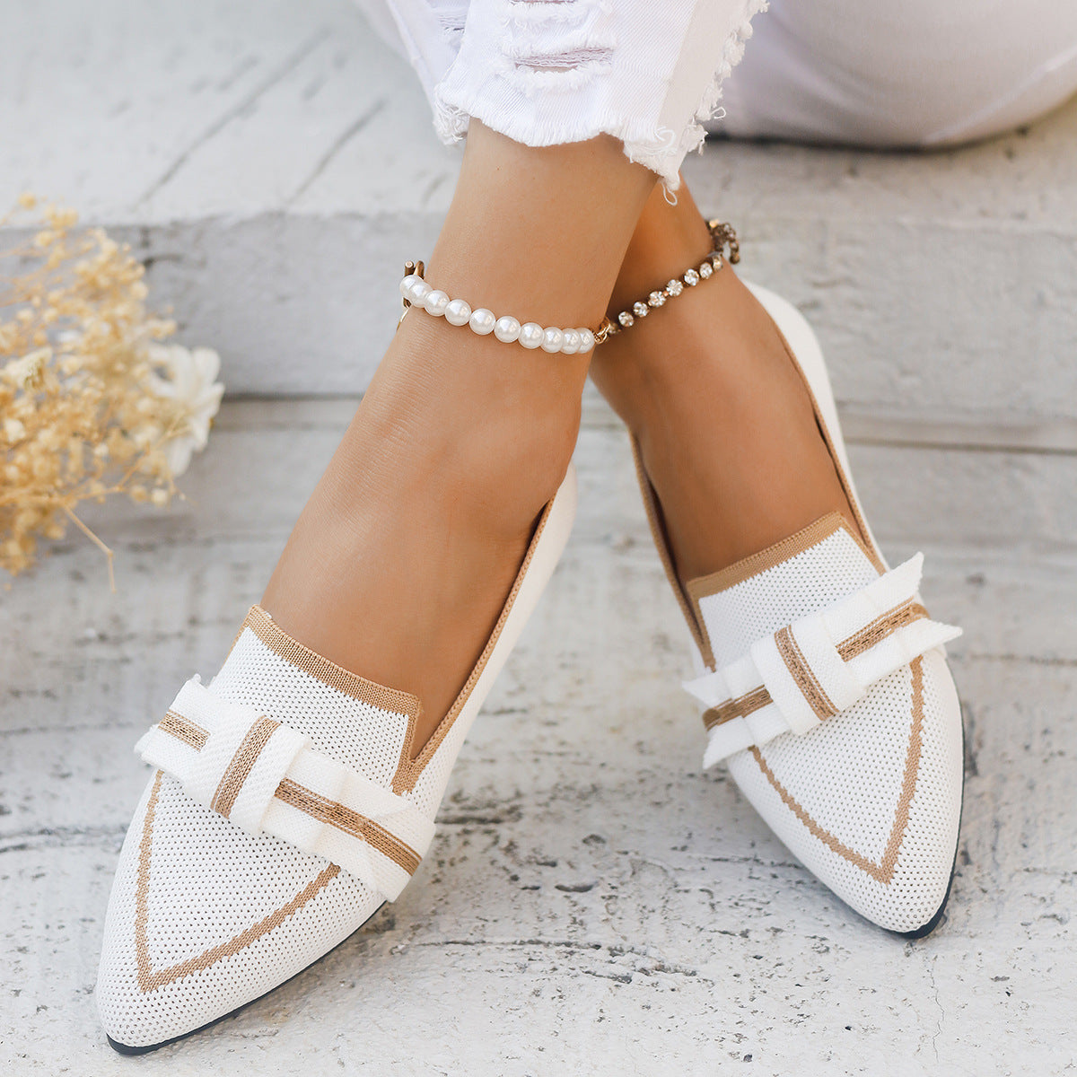Weiße Damen-Loafer mit Perlenknöchelband, elegantes Design, spitze Form, ideal für Sommermode, kombiniert mit zerrissenen weißen Jeans.