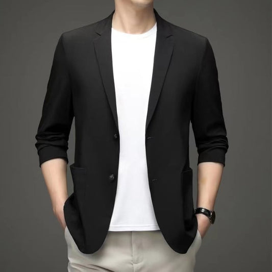 Mann in schwarzem Blazer und weißem T-Shirt, modisch elegant, Business-Casual-Look, grauer Hintergrund, moderne Herrenmode.