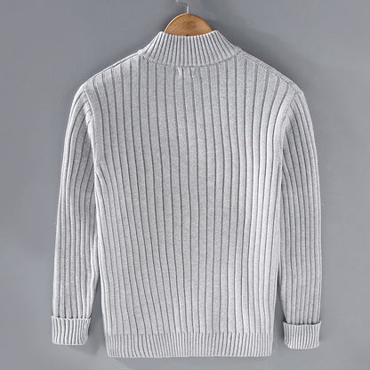 Grauer Strickpullover auf Holzkleiderbügel, Rückansicht. Modischer Herrenpullover, geripptes Design, warm und stilvoll. Ideal für Herbst- und Wintermode.