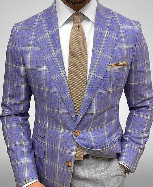 Mann im eleganten, karierten Anzug mit lila Muster, beiger Krawatte und Einstecktuch. Stilvolle Herrenmode, Business-Outfit, modischer Anzug.