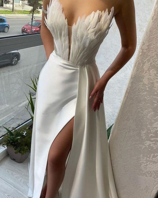 Elegantes weißes Abendkleid mit Federmuster und hohem Beinschlitz, ideal für formelle Anlässe. Modernes Design, luxuriöse Abendmode.