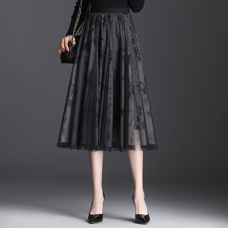 Frau in schwarzem Tüllrock, kombiniert mit schwarzem Oberteil und High Heels, hält eine kleine Handtasche. Elegante Damenmode, stilvoller Look.