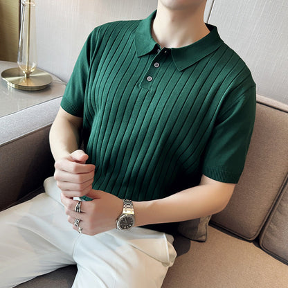 Grünes, geripptes Poloshirt aus Baumwolle, getragen von einer Person auf einem Sofa. Elegantes Design, ideal für Herrenmode und Freizeitkleidung.