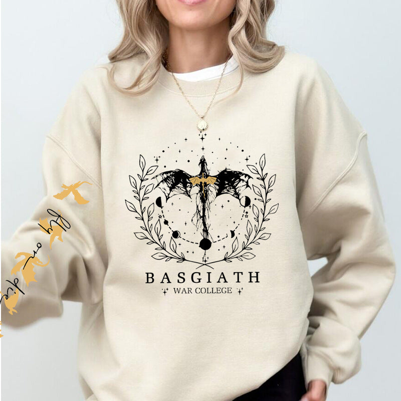 Frau trägt cremefarbenen Pullover mit schwarzem Drachen-Design und "BASGIATH WAR COLLEGE"-Schriftzug. Modischer Damenpullover, Fantasy-Mode.