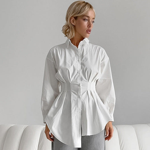 Eine Frau trägt eine weiße, taillierte Bluse mit langen Ärmeln. Elegante Damenmode, stilvolles Design, moderne Kleidung, zeitloser Look.