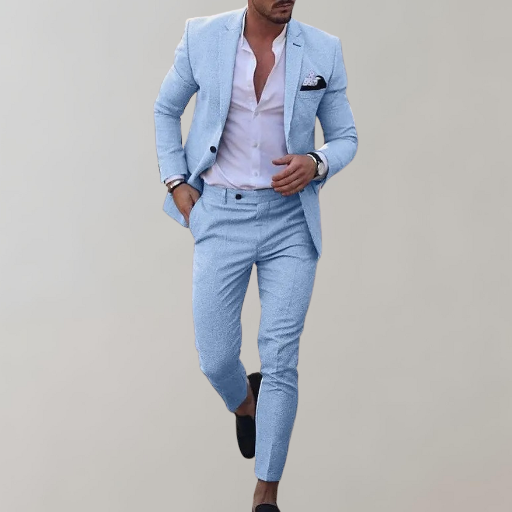 Mann in hellblauem Anzug mit weißem Hemd und schwarzem Einstecktuch, modisch gekleidet, läuft vor grauem Hintergrund. Elegante Herrenmode.