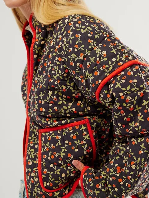 Damenjacke mit Kirschmuster, schwarzer Hintergrund, rote Kanten, gesteppte Optik, modisch, Herbstmode, florales Design, seitliche Taschen.