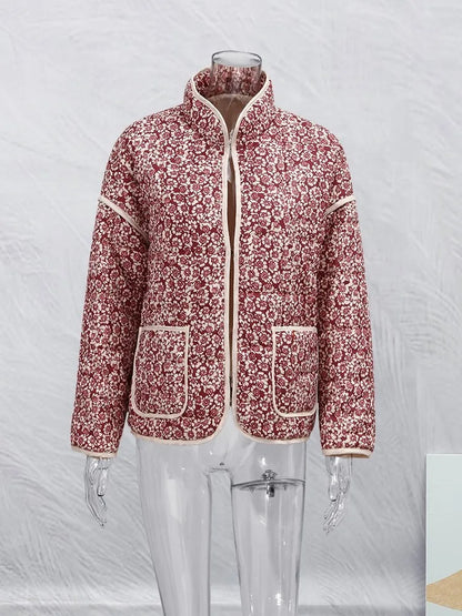 Rote Damenjacke mit Blumenmuster auf transparentem Mannequin, Stehkragen und Taschen. Modetrend, Herbstmode, stilvolle Damenbekleidung.