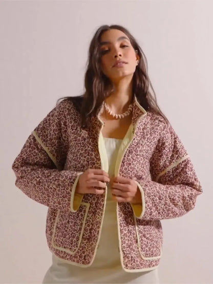 Frau trägt gemusterte Jacke mit Blumenmuster, gelben Akzenten und weißem Kleid. Modetrend, Damenmode, stilvolle Jacke, Herbstmode.