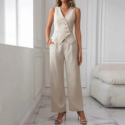 Frau in eleganter, cremefarbener Weste und Hose, steht in modernem, minimalistischem Wohnzimmer. Mode, Damenbekleidung, stilvoller Look.