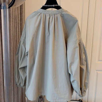 Beige Bluse mit Puffärmeln, Rückansicht. Modetrend, Damenbekleidung, elegantes Design, lässiger Stil, hochwertige Stoffe.