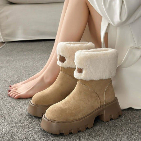Beige Damen-Winterstiefel mit dicker Sohle und weißem Kunstfellfutter, getragen von einer Person auf grauem Teppich. Ideal für kaltes Wetter.