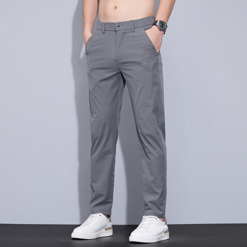Graue Herren-Chinohose, modern geschnitten, kombiniert mit weißen Sneakers. Ideal für lässige und elegante Outfits. Perfekt für den Alltag.