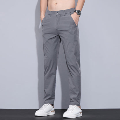 Graue Herren-Chinohose, modern geschnitten, kombiniert mit weißen Sneakers. Ideal für lässige und elegante Outfits. Perfekt für den Alltag.