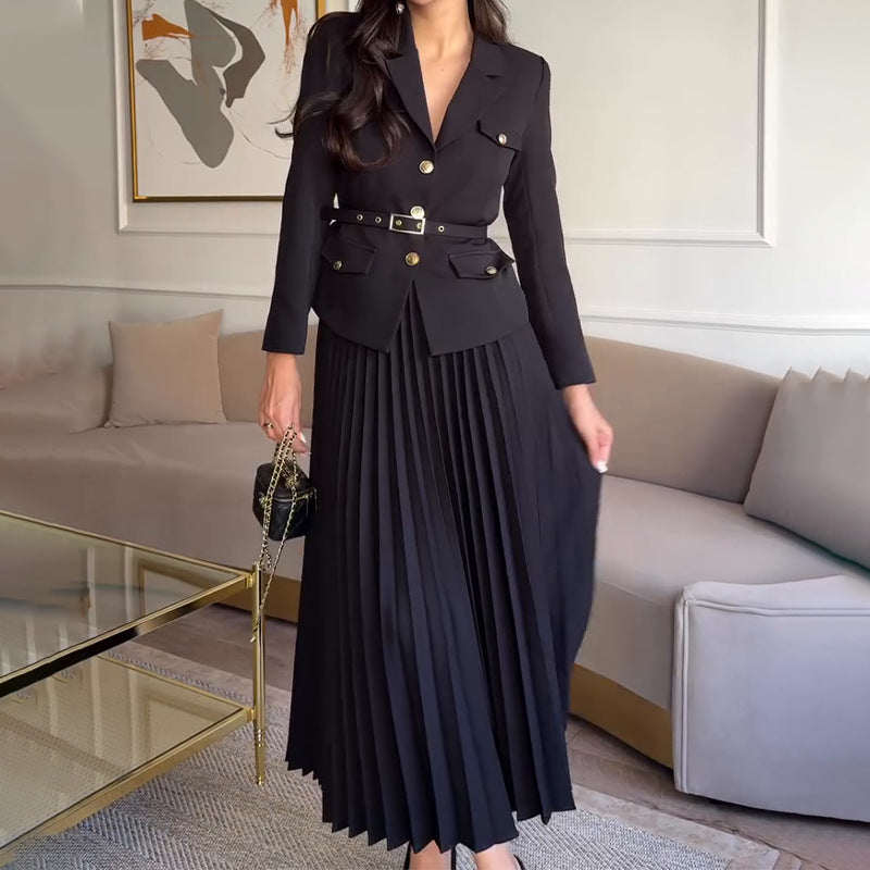 Elegantes schwarzes Damenkleid mit Blazer und Plisseerock, kombiniert mit goldenen Knöpfen und Gürtel, ideal für formelle Anlässe.