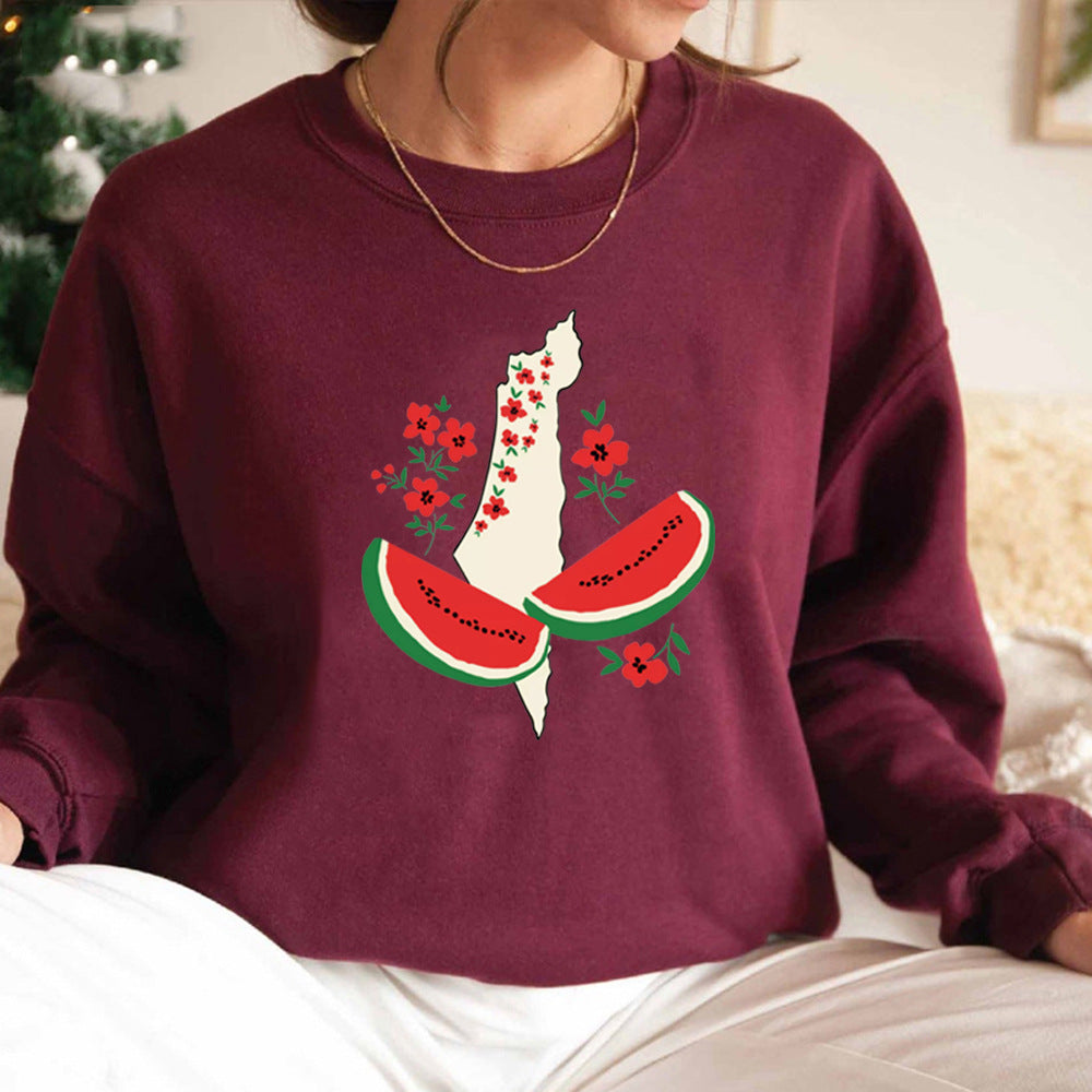 Frau trägt bordeauxroten Pullover mit Palästina-Karte, verziert mit Blumen und Wassermelonen-Design. Modetrend, Statement-Kleidung, Streetwear.