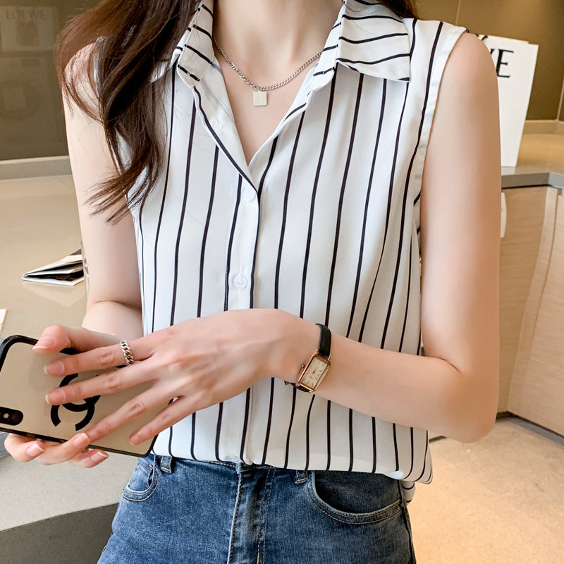 Frau in gestreifter ärmelloser Bluse, hält Smartphone, trägt Armbanduhr. Modetrend, Sommeroutfit, lässiger Stil, Damenmode.