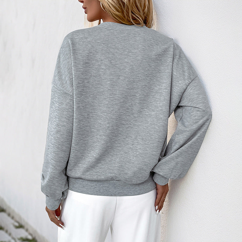 Frau in grauem Sweatshirt und weißen Hosen, Rückansicht. Modetrend, lässiger Stil, bequeme Kleidung, Damenmode, Freizeitoutfit.