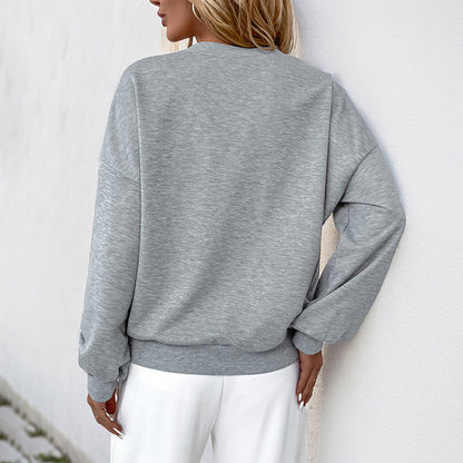 Frau in grauem Sweatshirt und weißen Hosen, Rückansicht. Modetrend, lässiger Stil, bequeme Kleidung, Damenmode, Freizeitoutfit.