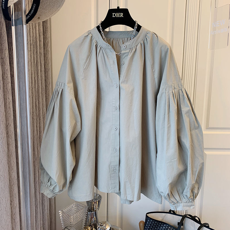 Hellblaue Bluse mit Puffärmeln auf einem Kleiderbügel. Modische Damenbluse, locker geschnitten, ideal für trendige Outfits. Elegante Kleidung für den Alltag.