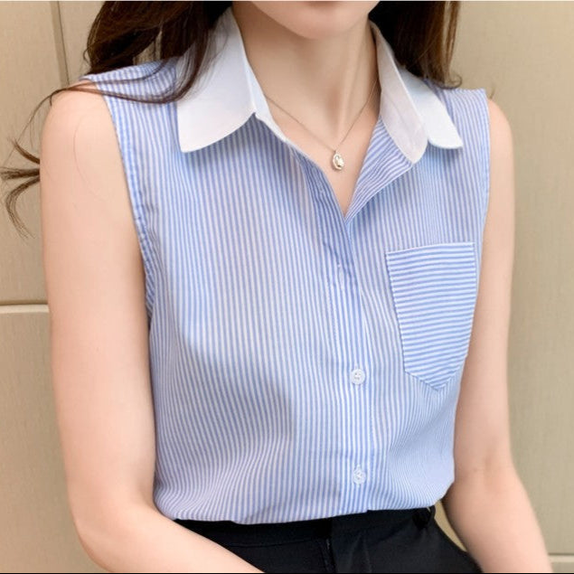 Frau trägt ärmellose, blau-weiß gestreifte Bluse mit Kragen und Brusttasche. Elegante Damenmode, ideal für Büro oder Freizeit.