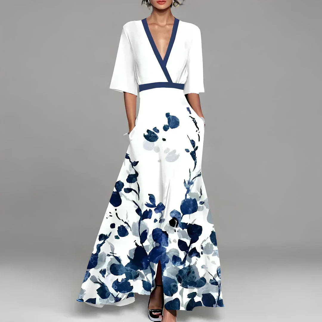 Elegantes weißes Maxikleid mit blauen Blumenmustern, V-Ausschnitt und kurzen Ärmeln. Perfekt für Sommermode und festliche Anlässe.