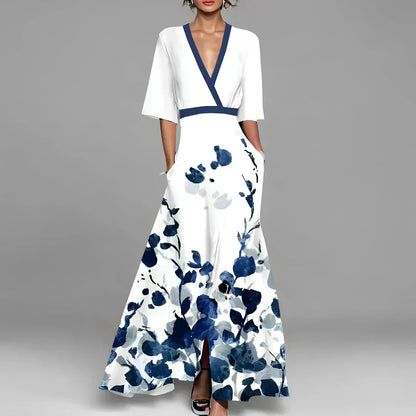 Elegantes weißes Maxikleid mit blauen Blumenmustern, V-Ausschnitt und kurzen Ärmeln. Perfekt für Sommermode und festliche Anlässe.