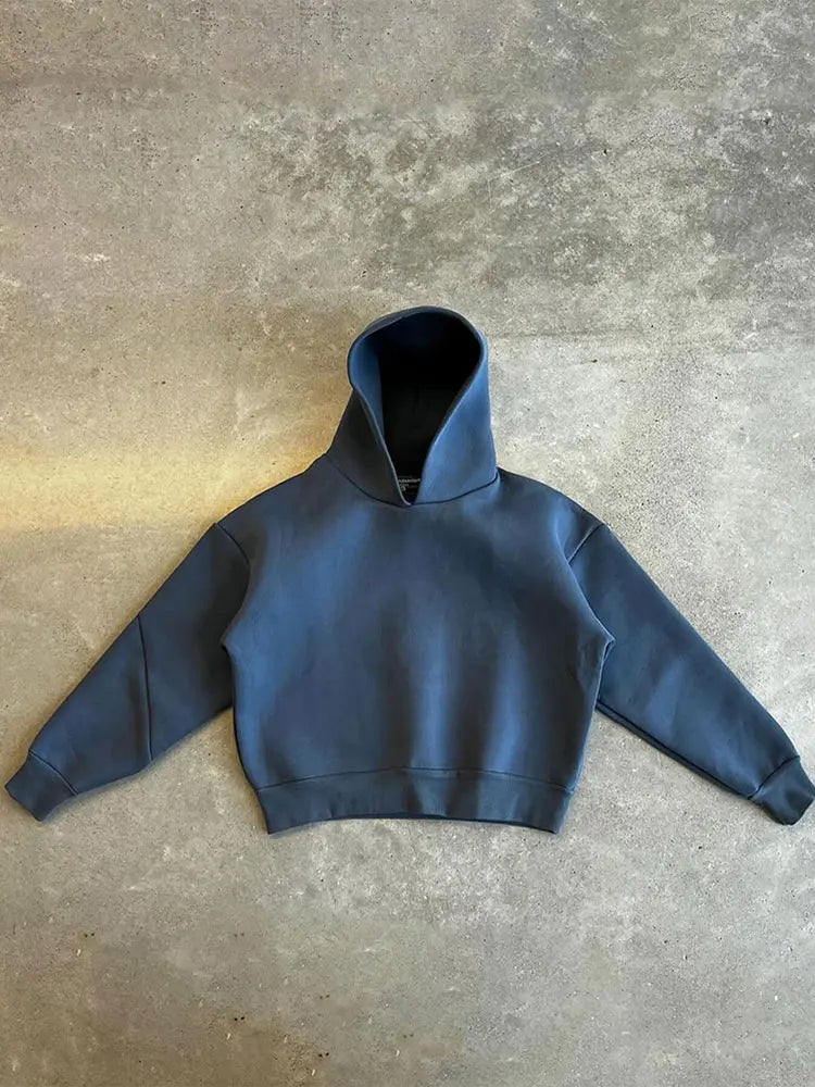 Dunkelblauer Kapuzenpullover auf grauem Betonboden, minimalistisch, modisch, Streetwear, Unisex-Hoodie, lässiger Stil, Herbstmode.