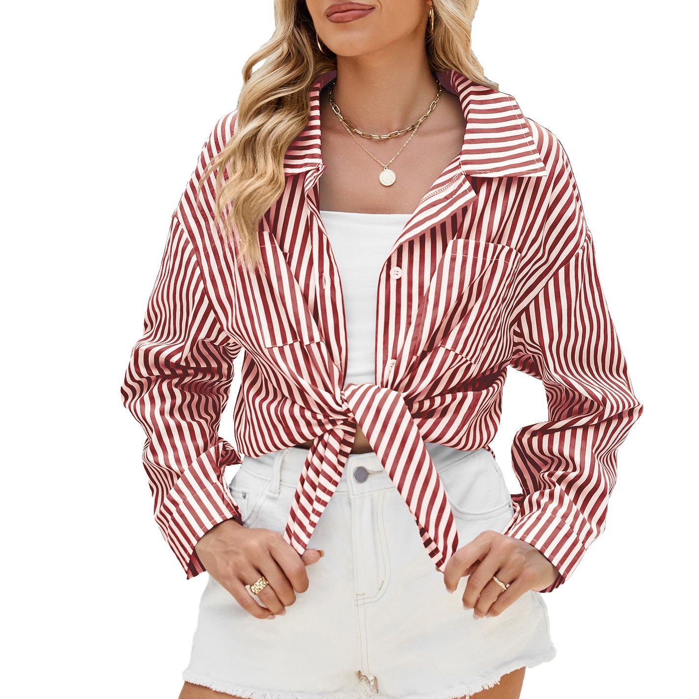 Frau in rot-weiß gestreifter Bluse, geknotet, mit weißem Top und Jeansshorts. Modetrend, Sommeroutfit, lässiger Stil, Damenmode.