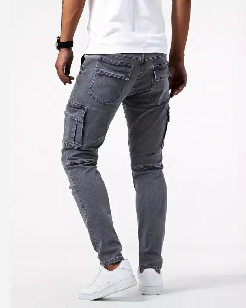 Graue Cargo-Jeans für Herren, Rückansicht. Modische, lässige Hose mit Taschen, kombiniert mit weißen Sneakers und weißem T-Shirt.