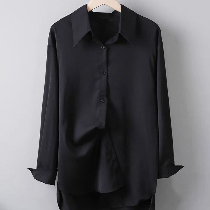 Schwarzes Seidenhemd auf Holzkleiderbügel, langärmlig, klassischer Kragen, Knopfleiste, elegantes Design, ideal für formelle Anlässe.