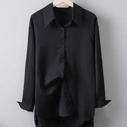 Schwarzes Seidenhemd auf Holzkleiderbügel, langärmlig, klassischer Kragen, Knopfleiste, elegantes Design, ideal für formelle Anlässe.