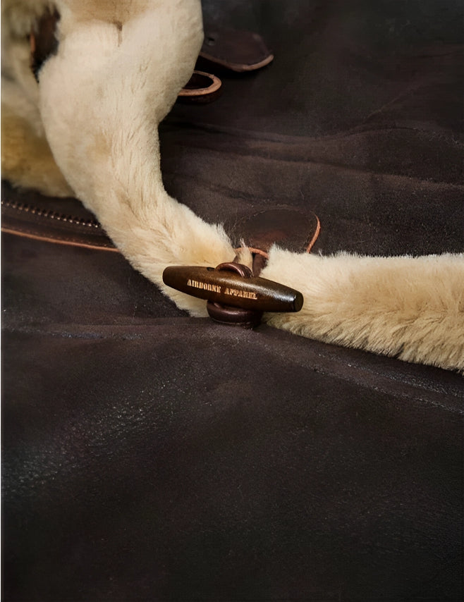 Dufflecoat mit Holzknopf und Kunstfellkragen, braunes Leder, Detailaufnahme. Hochwertige Wintermode, stilvoll und warm.