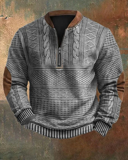 Grauer Strickpullover mit Zopfmuster, Reißverschluss und braunen Ellbogen-Patches vor rustikalem Hintergrund. Herrenmode, Winterkleidung, stilvoll.