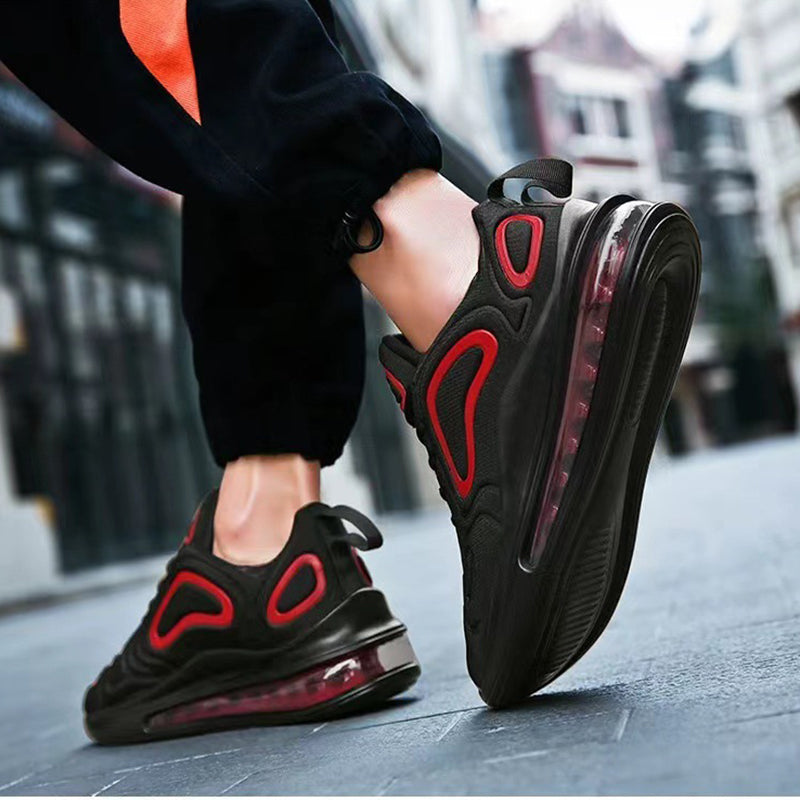 Schwarze und rote Sportschuhe mit Luftpolstersohle, getragen auf städtischer Straße. Moderne Sneaker, ideal für Laufen und Freizeit.