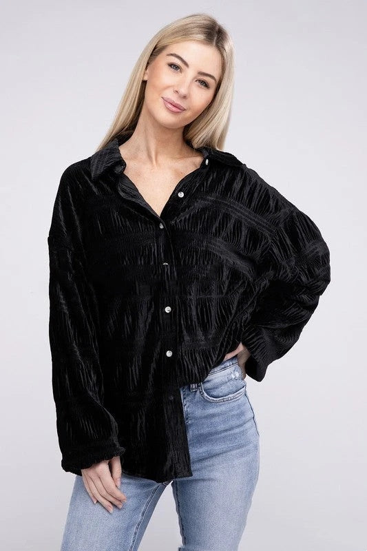 Eine Frau trägt eine schwarze, langärmelige Bluse aus Samt und blaue Jeans. Mode, Damenbekleidung, eleganter Look, Freizeitoutfit.