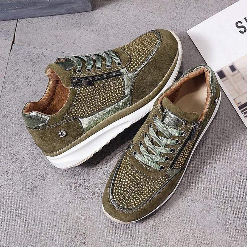 Grüne Sneaker mit Nieten, Reißverschluss und weißer Sohle auf grauem Hintergrund. Modische Herrenschuhe, ideal für Freizeit und Sport.