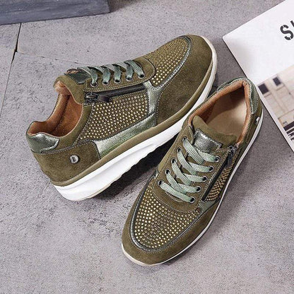 Grüne Sneaker mit Nieten, Reißverschluss und weißer Sohle auf grauem Hintergrund. Modische Herrenschuhe, ideal für Freizeit und Sport.