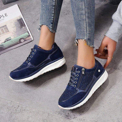 Damen Sneaker in Dunkelblau mit weißer Sohle, Reißverschluss und Schnürsenkeln, getragen mit Jeans. Modische Freizeitschuhe für Frauen.