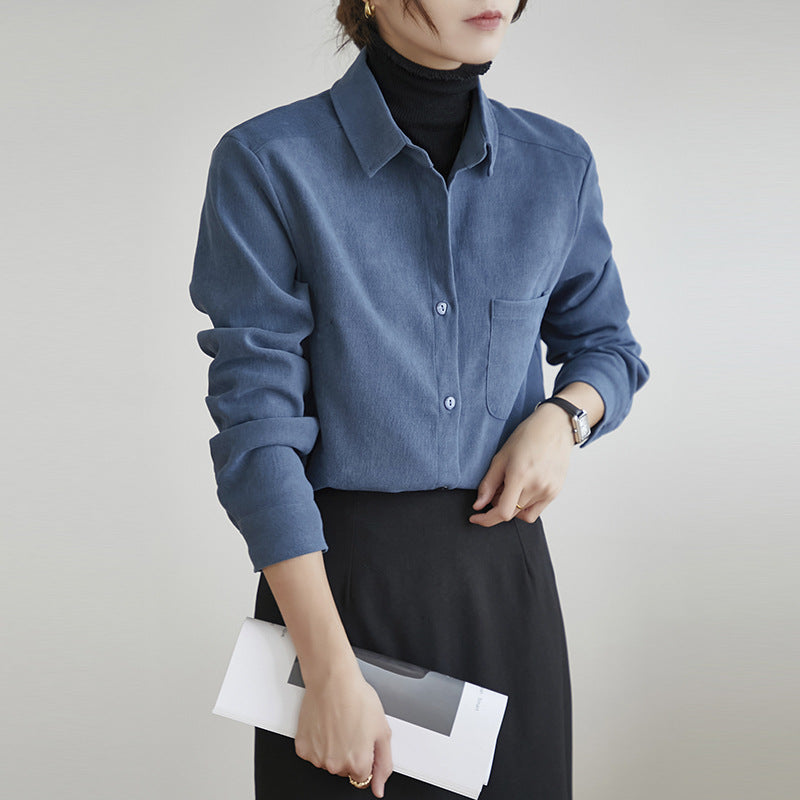 Frau in blauer Bluse und schwarzem Rock hält ein Buch. Elegante, moderne Damenmode, Büro-Outfit, stilvolle Kleidung.