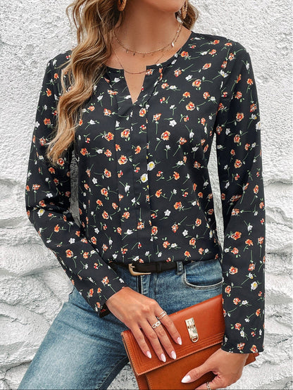 Frau in schwarzer Bluse mit Blumenmuster, blaue Jeans, braune Lederhandtasche, vor weißer Wand. Modetrend, Damenmode, Freizeitlook.