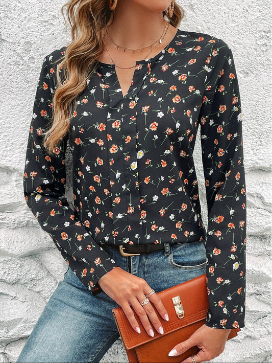 Frau in schwarzer Bluse mit Blumenmuster, blaue Jeans, braune Lederhandtasche, vor weißer Wand. Modetrend, Damenmode, Freizeitlook.